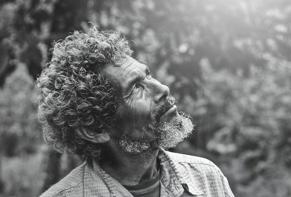 homme âge émerveillé par la lumière, en noir et blanc